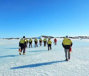The group of expeditioners is walking over sea ice in Long Fjord, learning how to navigate.
