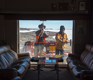 Another photo of Mark and Rohan cleaning the windows, taken from inside the building.