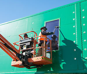 A zoomed in photo of Mark and Rohan scraping the mud off the windows.