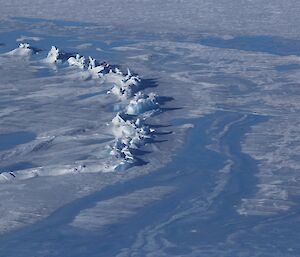 There is a feature on the glacier that is an arc of what looks like frozen surf, next to the smooth blue ice of the frozen lake