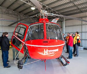 Expeditioners are getting a tour of the helicopter inside the heli hanger.