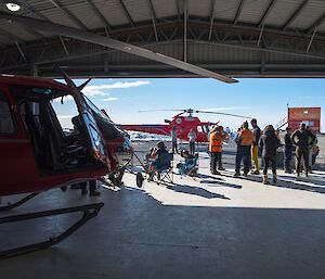 The view from inside the heli hanger looking out onto people enjoying the BBQ. The helicopter can be seen in the foreground.