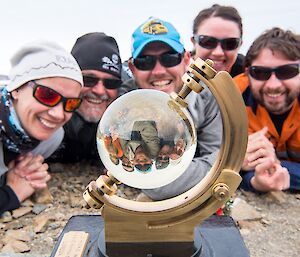 Daleen, Barry, Damo, Rachel and Aaron are lying in a half circle, on the ground, looking at the sunshine recorder. This device looks like a hybrid between a sextant and a crystal ball.