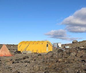 The Infrasound campsite: a large yellow RAC tent is the living area; the small red polar pyramid tent is the ablutions; and the hut in the distance is the building housing the electronic equipment.