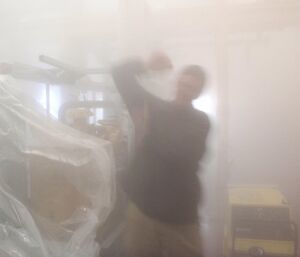 An expeditioner enjoys the steam bath provided by the hi-fog system when the water is released.