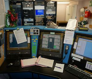 The communications desk at Davis. There are three computer screens, two with radio call and one with aviation tracking.