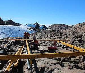 A team of expeditioners putting together the four outer edges of the new deck.