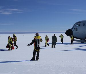 Disembarking passengers are guided off the plane.