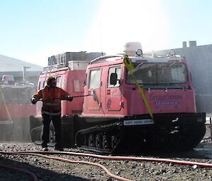 Jock is seen brushing the side of the pink Hägg with a broom. This is to help dislodge the dirt before the fire hose does another sweep of the vehicles.