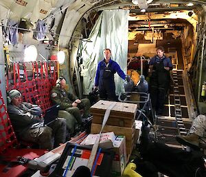 Military personnel, are standing inside the Hercules as it travels to Antarctica.