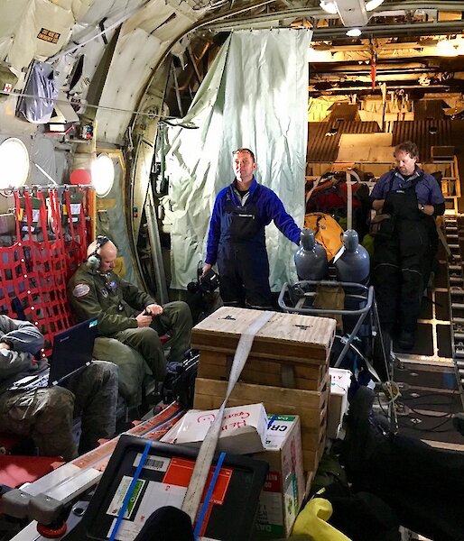 Military personnel, are standing inside the Hercules as it travels to Antarctica.