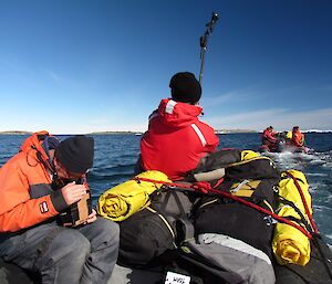 Pete looks through a monitor and Mark holds the camera on a stick to get height as the two boats cruise towards Gardner Island.