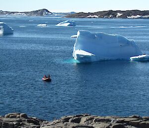 A view of a boat travelling near an iceberg, taken from the high point of Gardner Island.