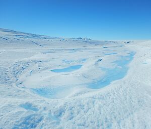 A large blue pool on the glacier’s surface is seen in the centre of an old lake basin at the Chanel Lake site.