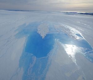 A lake of open water sits on the surface of the Sorsdal Glacier — aerial view.