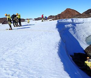 The edge of Trajer Ridge. Some people are standing on the ice ridge, while others are at the bottom, having abseiled down.