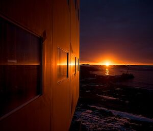The sun is sitting on the horizon, creating a glow on the Living Quarters building.