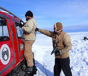 Jock is pushing against Marc’s back as Marc tapes the doors shut. Without this support Marc would fall off the vehicle tracks.