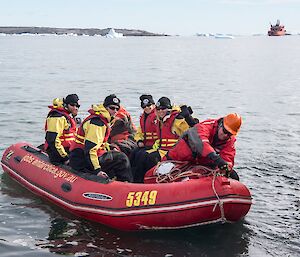 Ray, Matt, Anna and Phoebe are in the zodiac with two crew. They are just leaving the boat ramp and about to head out to the ship which is on the horizon.