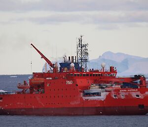 The Aurora Australis is sitting near icebergs off Davis. The openings in the hull look a bit icy. The ship has just arrived from Mawson.