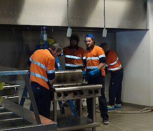 Barry, Shoey and Bryce have pulled the dirty old stove out from the wall and are about to start cleaning it. The rest of the kitchen has been gutted for cleaning.