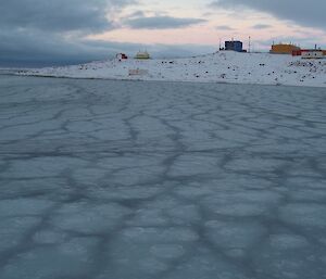 Newly formed sea-ice is present in clumps in the bay. Davis station is in the background.