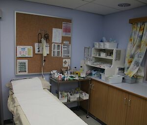 The Clinic on station: it has an examination table, blood pressure machine, and many boxes of bandages, gloves, swabs and medical paraphenalia.