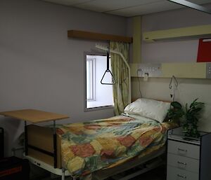The recovery ward with a bed, a handle to pull yourself upright in bed and a window.