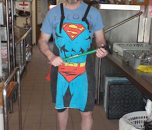Fitzy is in the kitchen, wearing a superman apron while being slushy.