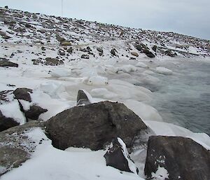 Rocks down in the waters edge are covered in ice; including those below the water’s surface.