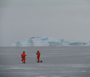 An expeditioner uses the drill to take an ice core.