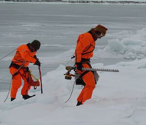 Two expeditioners back on shore with all the coring equipment.