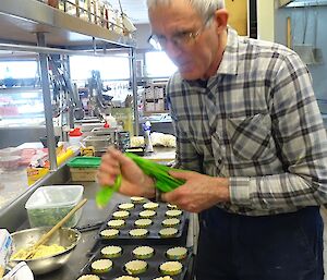 Rob piping muffin mix into cup cakes.