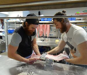 Shoey and Bryce cutting the fettucini into ribbons as it goes through the dough rolling machine.