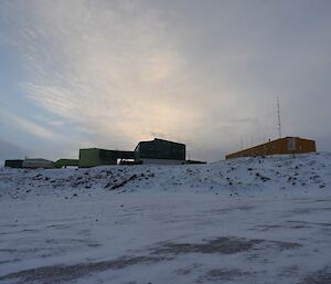 A photo of the station buildings taken from the seaice. Behind the buildings is blue sky but it’s early and still a bit dark.