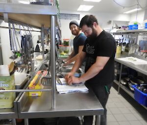 Bryce and Millsy are in the kitchen making a Saturday night dinner. Millsy si working with pastry on the bench. Bryce is working beside him.