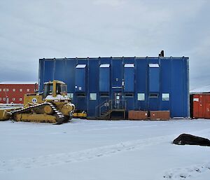 The blue Powerhouse building is seen with a bulldozer and elephant seal in front of it.