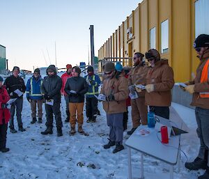 The Address being given by Kirsten, Station Leader. The other expeditioners are gathered around listening.