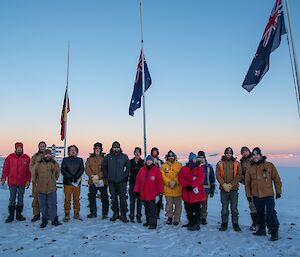 A team photo under the flags at dawn, following the Davis ANZAC Day service.