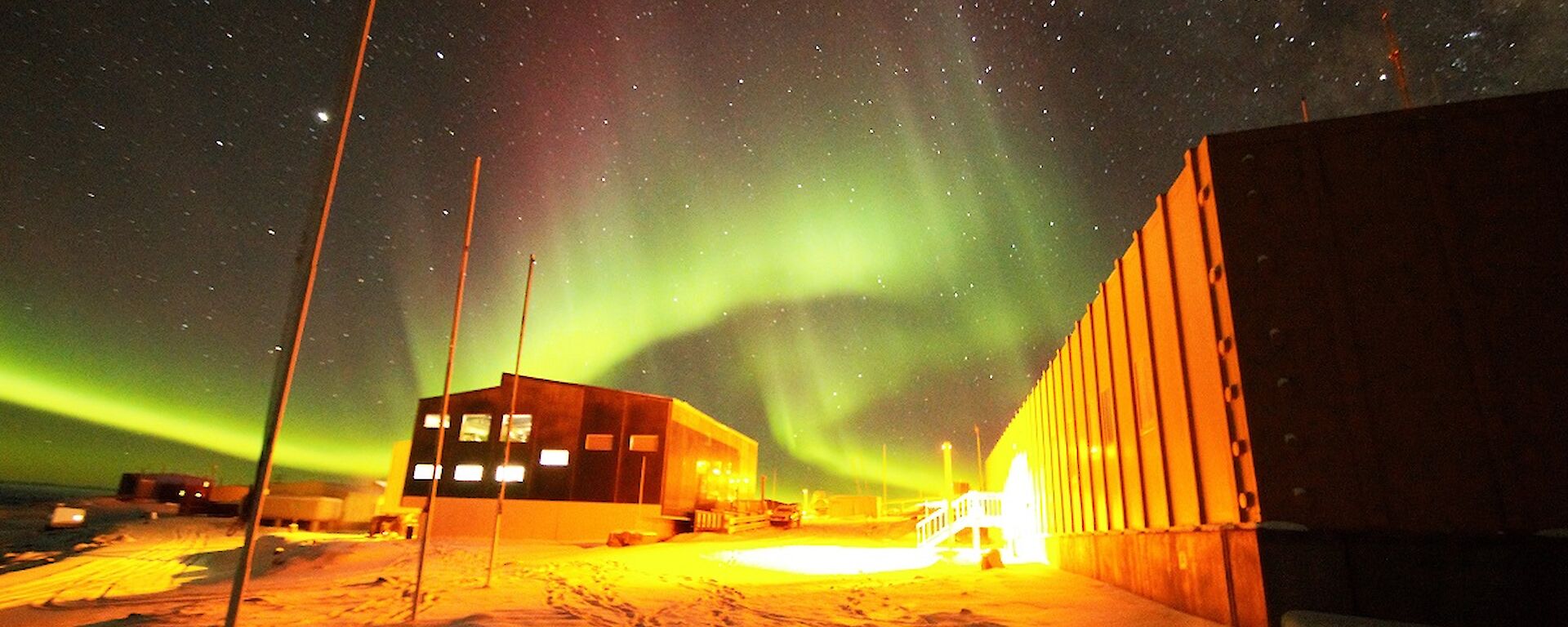 A green and magenta aurora is over the Living Quarters and Operations buildings.