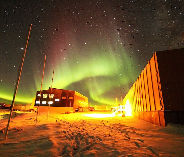 A green and magenta aurora is over the Living Quarters and Operations buildings.