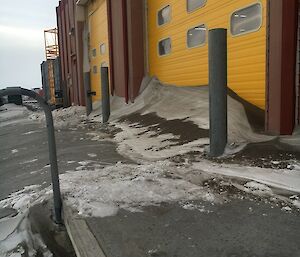 The outside of the workshop garage doors which have snowdrift piled up against them.