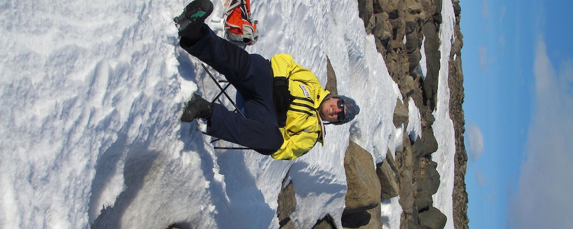 Ralph is sitting in a deck chair, on the snow at Marchant’s Landing.