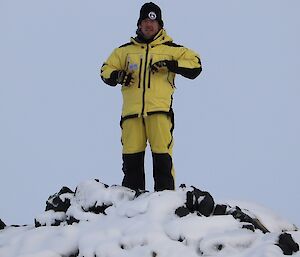 Ralph is dressed in his outdoor yellow gear, standing on a hill on Anchorage Island.