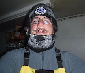 Ralph’s neck gaiter and hat are covered in ice. He’s inside the field hut, having just walked several hours to get there.