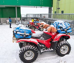 The quad bikes are parked in the snow outside the Living Quarters. Survival packs are loaded up, ready to go.