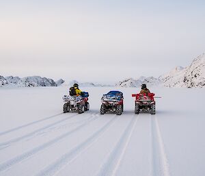 The three quads are stopped in the snow on Long Fjord as the team look east towards the Antarctic Plateau.