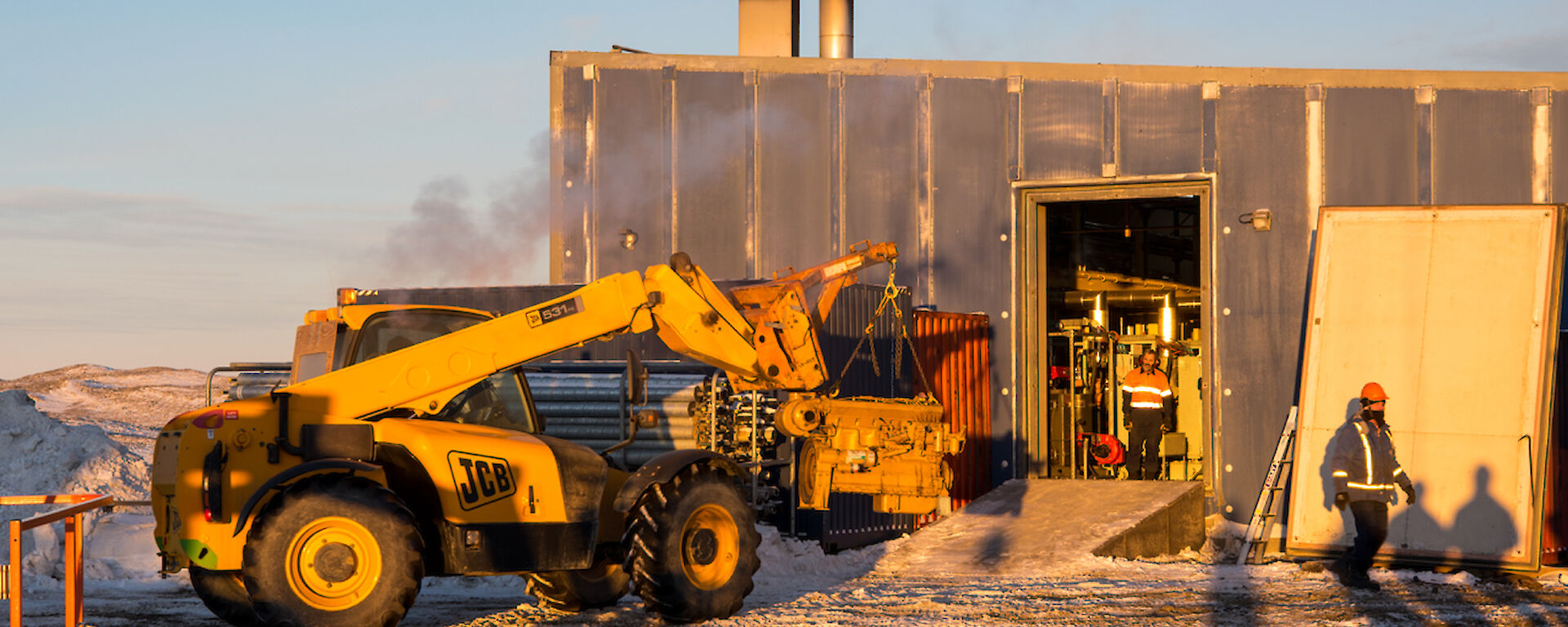 The old engine is removed through the side panel using the JCB.