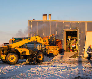 The old engine is removed through the side panel using the JCB.