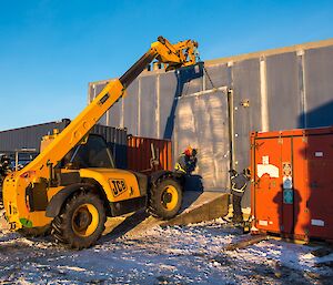 The side panel is being placed back into position, using the JCB.